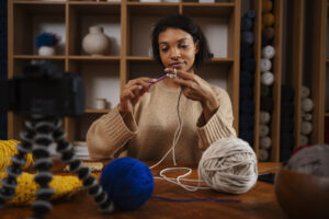 medium shot woman knitting camera